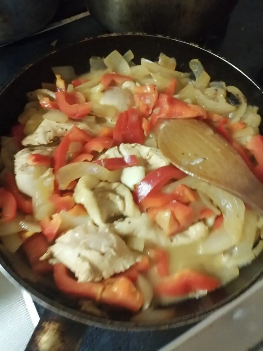 チキンパプリカッシュの調理過程：鶏肉、玉ねぎ、パプリカを炒めている様子