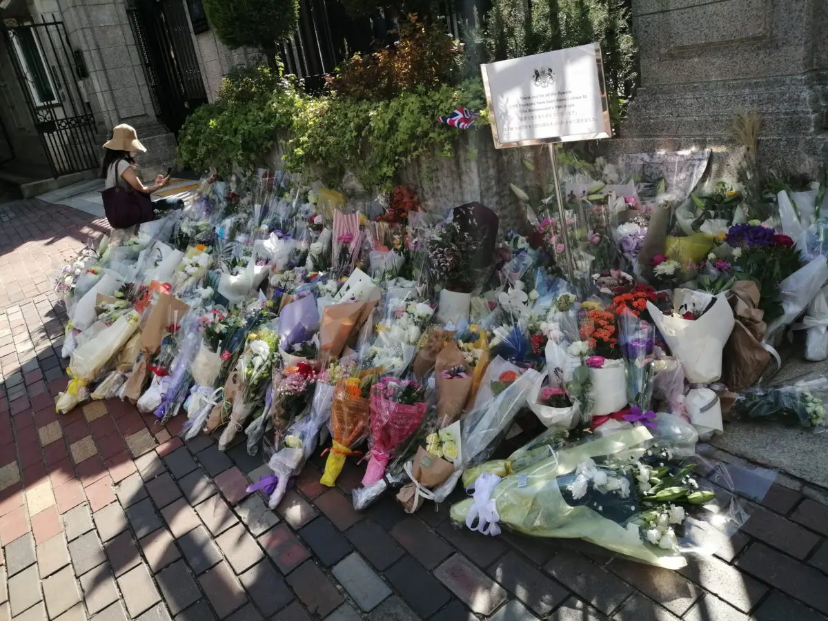 供花に手を合わせる弔問客