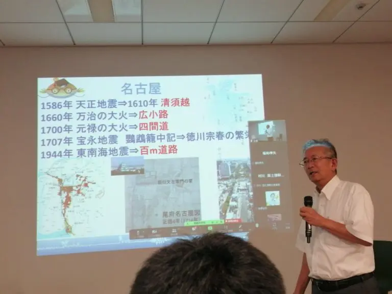 名古屋大学名誉教授 福和伸夫氏が、名古屋の地震・災害履歴に関するスライドを背景に講演中。
