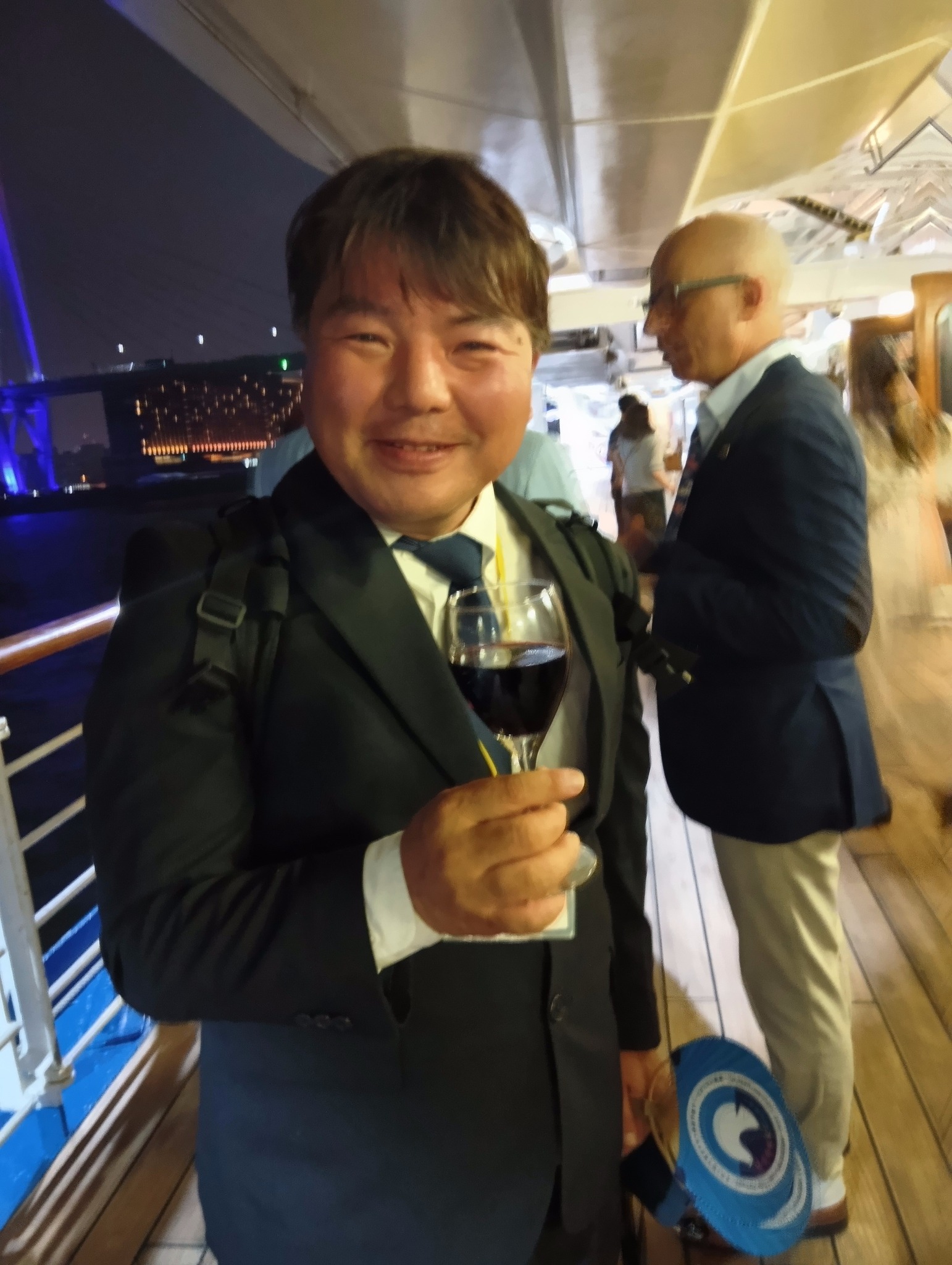 2025年TIME FOR PEACE 国連中満事務次長、万博イタリア館長と語り合った大阪港の夜 4 「Time For Peace」イベントの懇親会で、ワイングラスを片手に微笑む榊原平