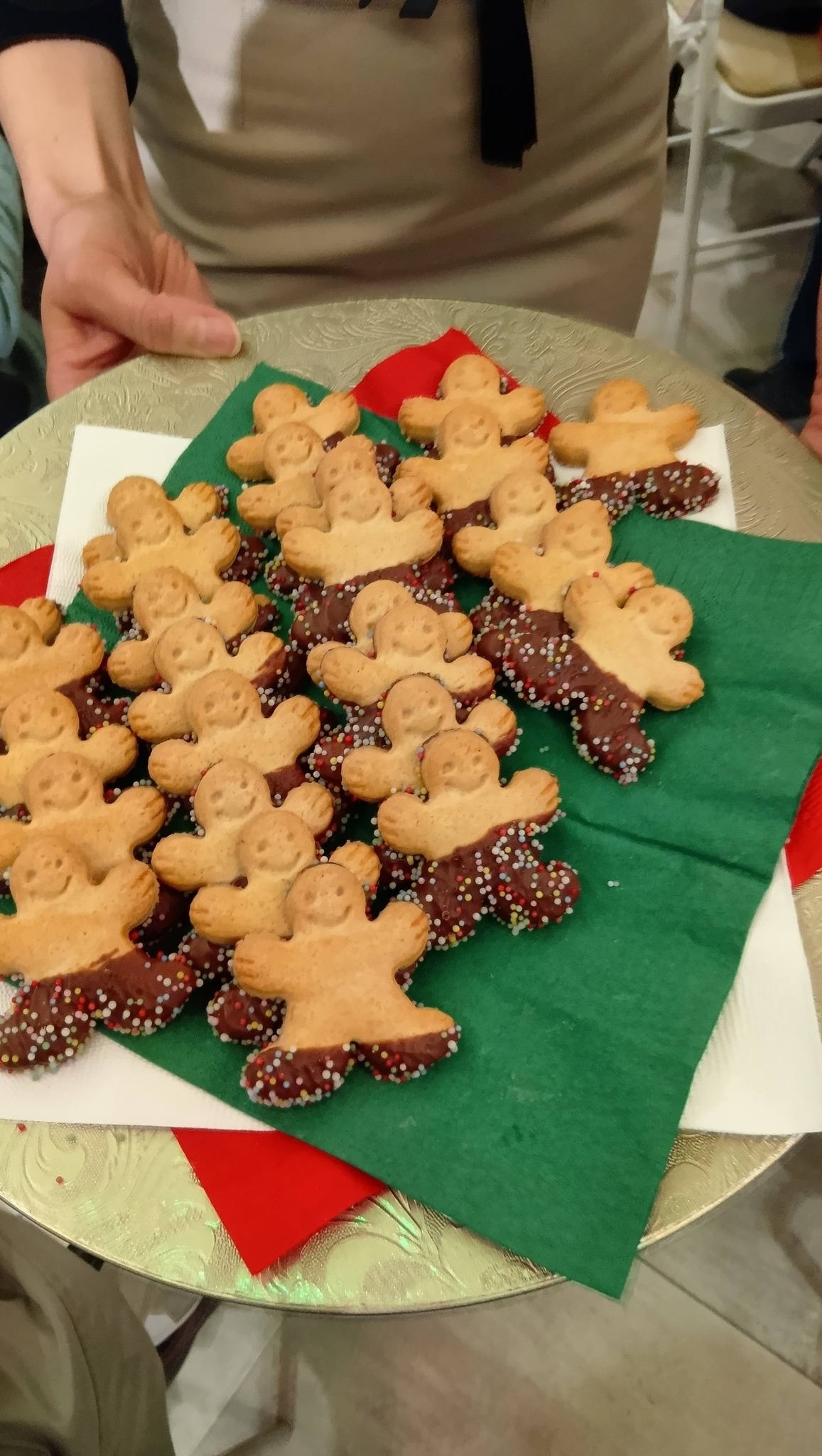 リスト音楽院創立150周年記念展覧会 特別コンサート|天川真奈さんが奏でるベヒシュタインの調べ 3 緑色のナプキンの上に、チョコとカラフルなトッピングでデコレーションされた人型のジンジャーブレッドがたくさん並べられている様子。