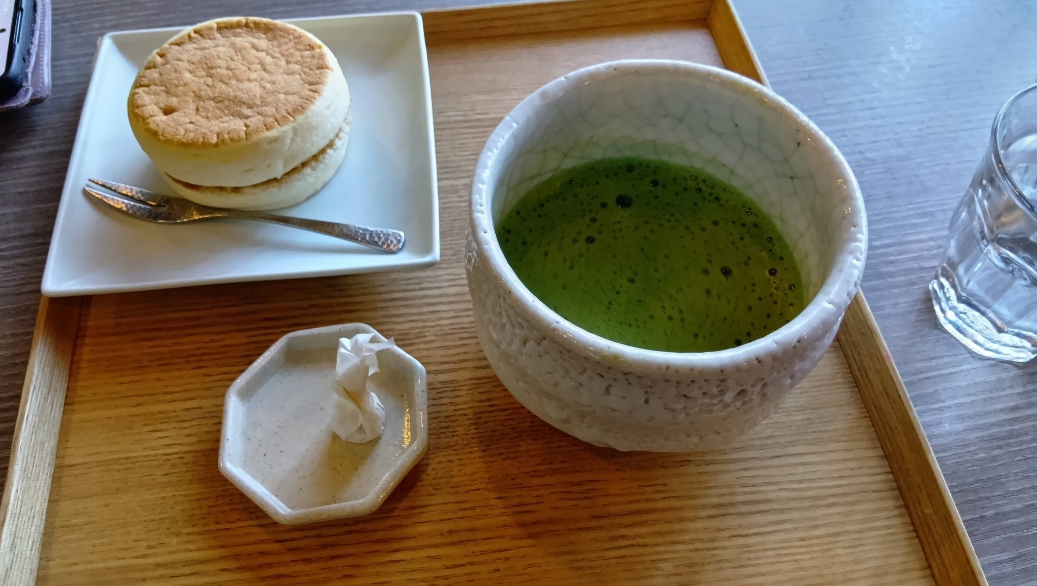 名古屋能楽堂 新春謡初め2026 五流派が揃う感動の伝統芸能 6 木製のトレイに載せられた抹茶とあんバターパン。白い和食器に入った抹茶と、白いお皿に載ったあんバターパン。手前には小さなお菓子が添えられている。