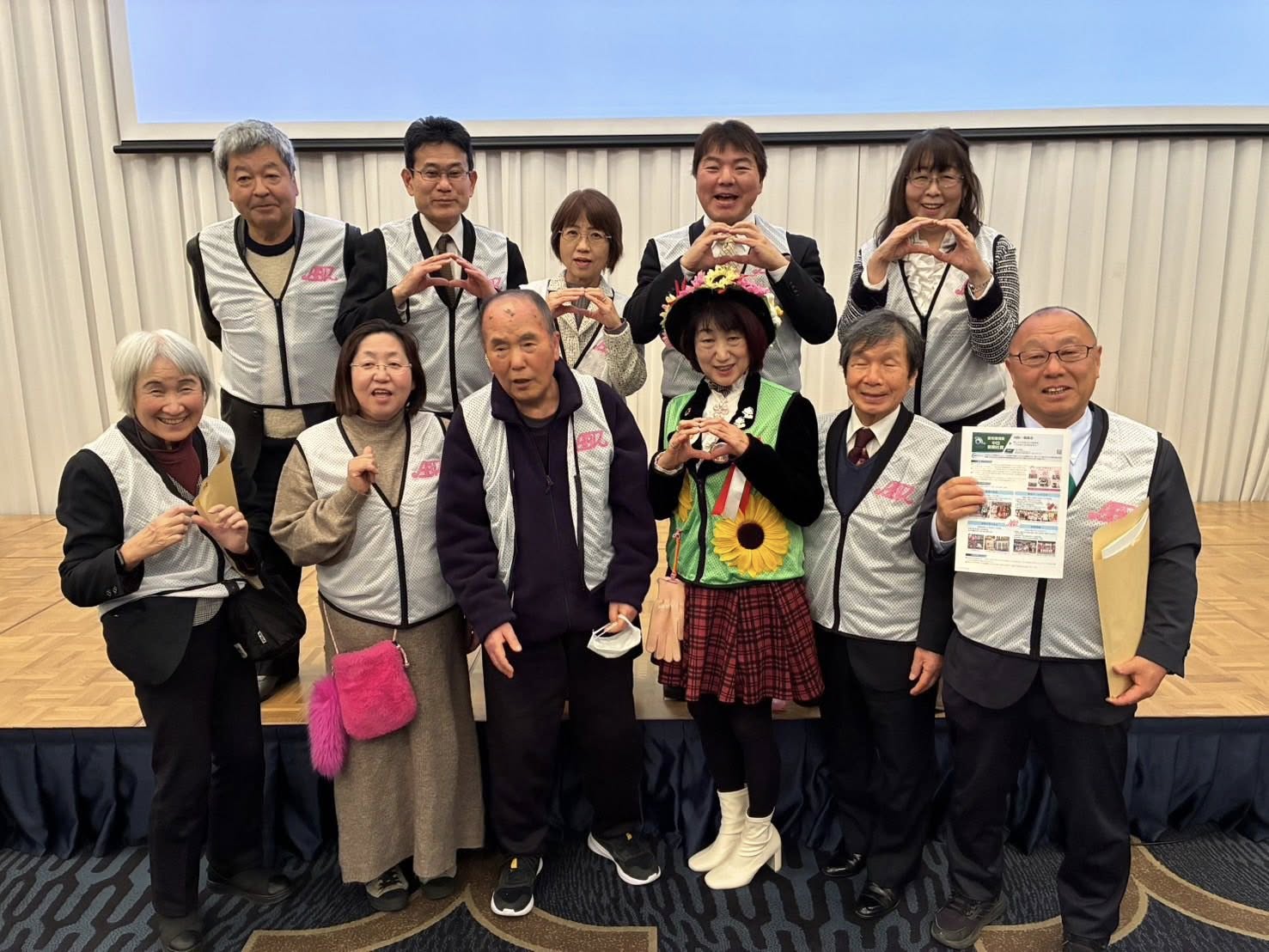 2026愛知環境賞の表彰式後の記念撮影。大村知事とABK♡朝美活の野村代表、およびメンバーが並び、中央で野村代表が中日新聞社賞の表彰状を手にしている。