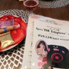 テーブルの上に置かれたワイングラスとお菓子とマリーズサロンシリーズ メノッティ THE Telephoneのプログラム
